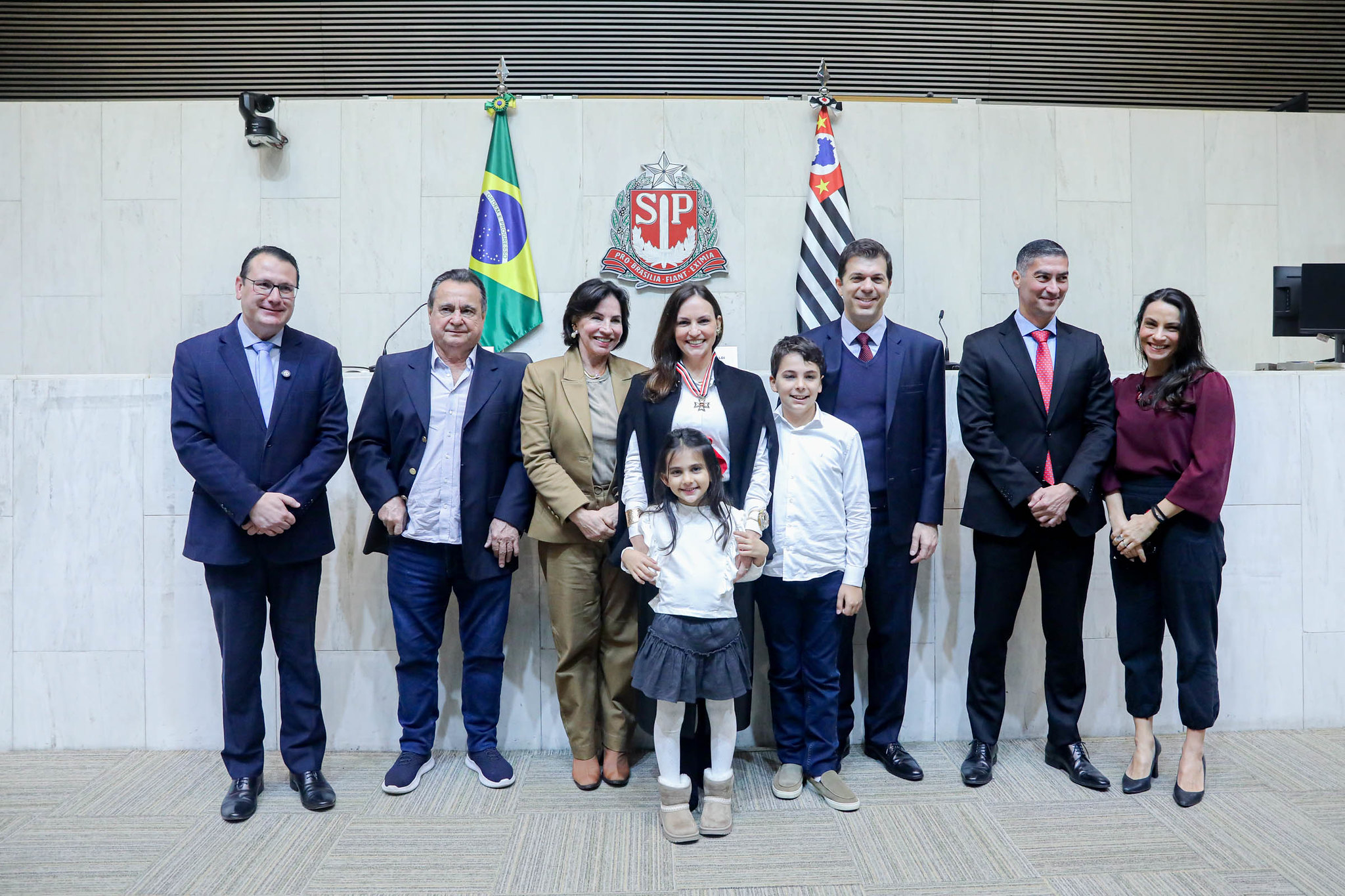 Leticia recebe Colar rodeada por familiares <a style='float:right' href='https://www3.al.sp.gov.br/repositorio/noticia/N-06-2026/fg365525.jpg' target=_blank><img src='/_img/material-file-download-white.png' width='14px' alt='Clique para baixar a imagem'></a>