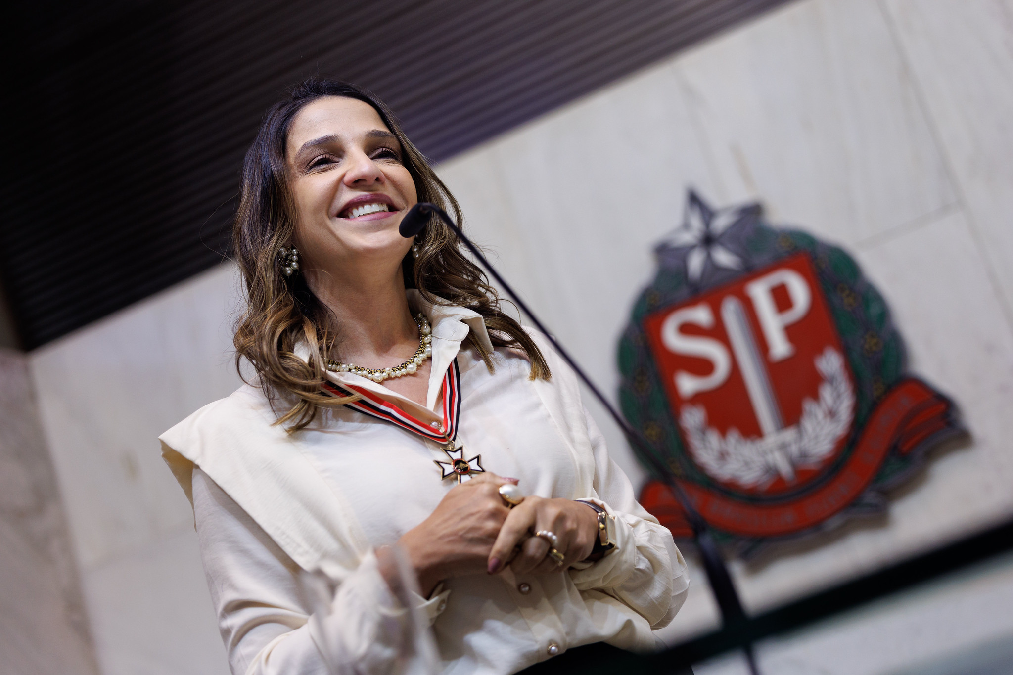 Colar de Honra ao M�rito � Ana Carolina Oliveira.<a style='float:right' href='https://www3.al.sp.gov.br/repositorio/noticia/N-06-2026/fg365561.jpg' target=_blank><img src='/_img/material-file-download-white.png' width='14px' alt='Clique para baixar a imagem'></a>